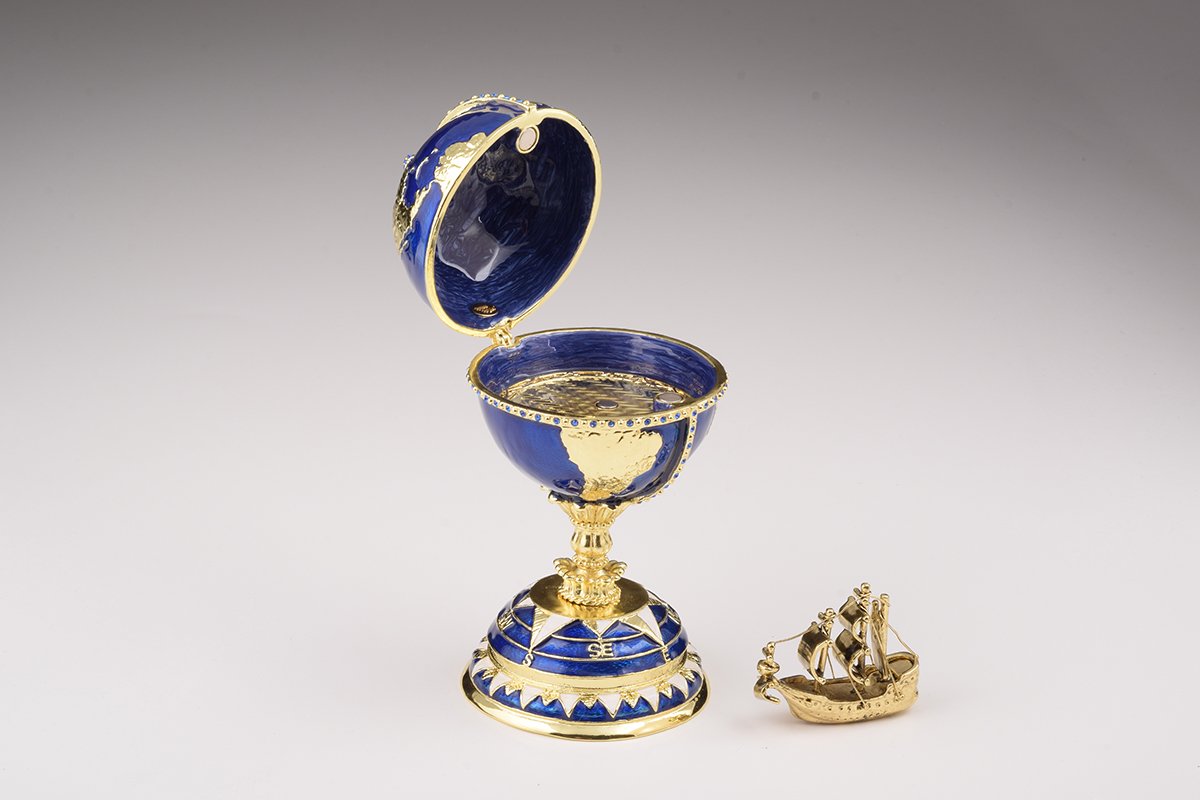 A beautifully crafted Globe Faberge Egg trinket box featuring a sailing ship design, adorned with Austrian crystals and plated in 24K gold or 925 silver.