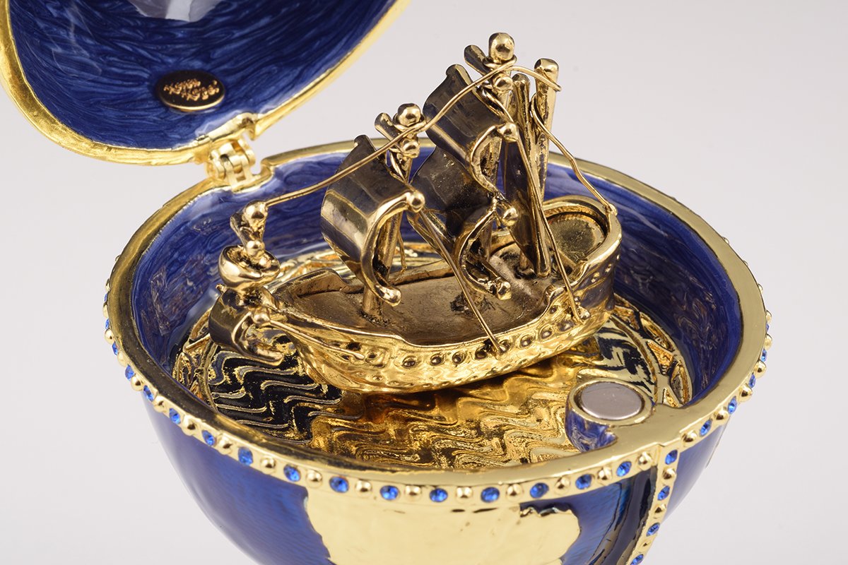 A beautifully crafted Globe Faberge Egg trinket box featuring a sailing ship design, adorned with Austrian crystals and plated in 24K gold or 925 silver.