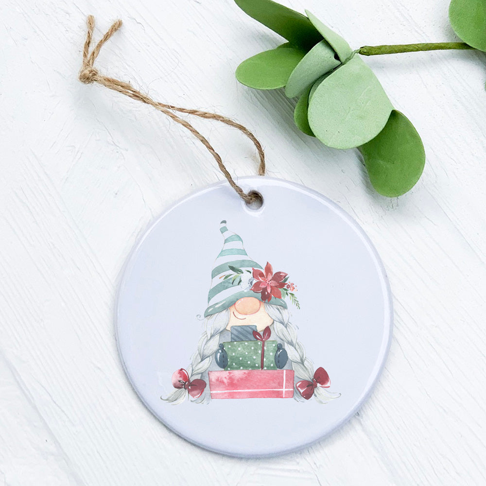 A charming porcelain ornament featuring a gnome holding presents, showcasing vibrant colors and a glossy finish.