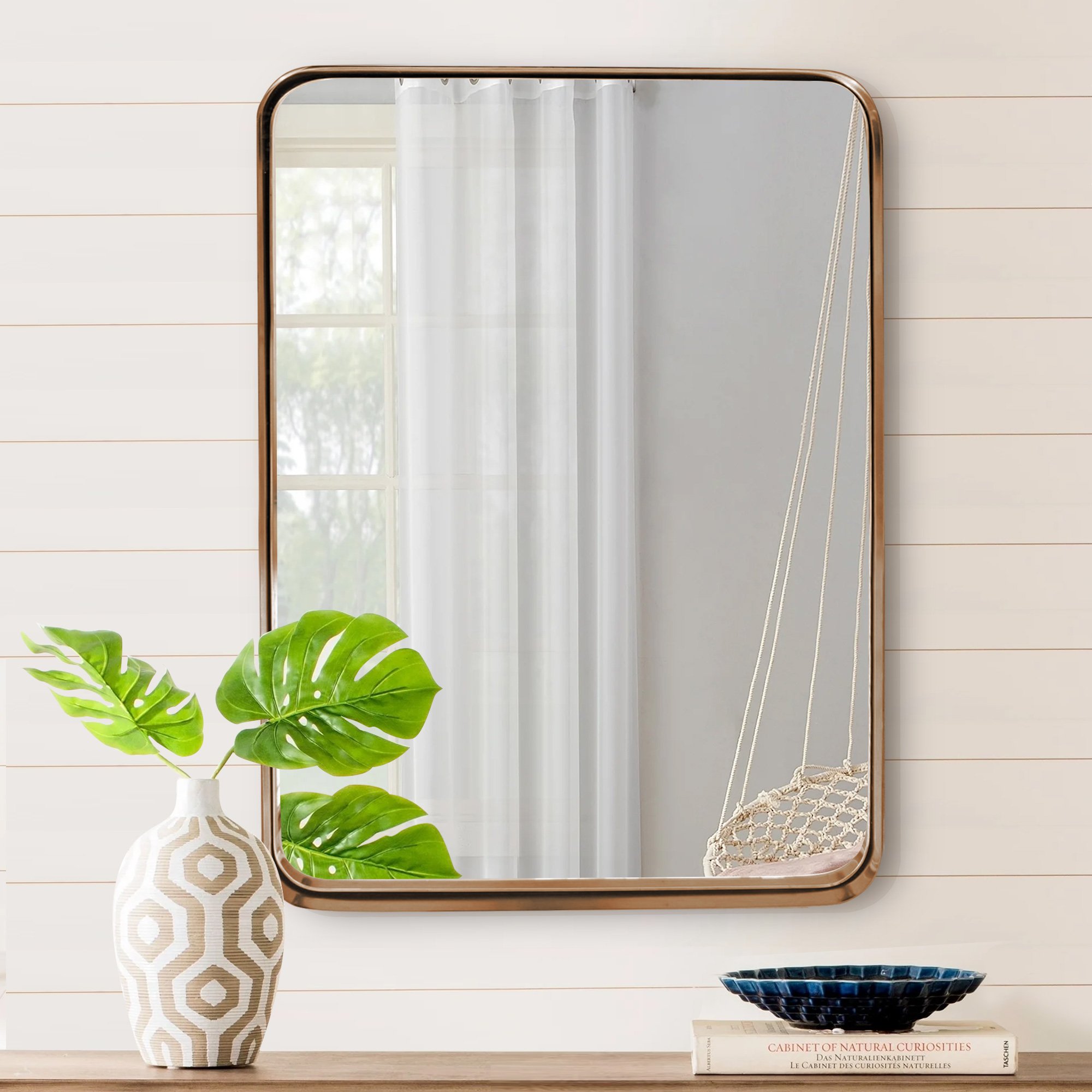 A luxurious gold bathroom hanging mirror measuring 22x30 inches, featuring a hand-brushed brass frame with round corners and an infinity design.