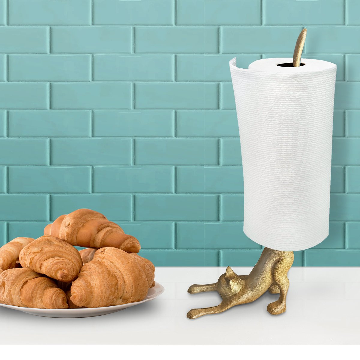 A whimsical gold cat paper towel holder made of cast iron, featuring a stretching cat design with a tail that holds paper towel rolls.