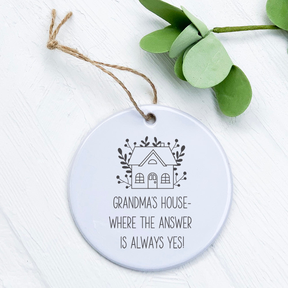 A beautifully crafted porcelain ornament featuring the phrase 'Grandma's / Nana's Answer is Yes', showcasing vibrant colors and a glossy finish.