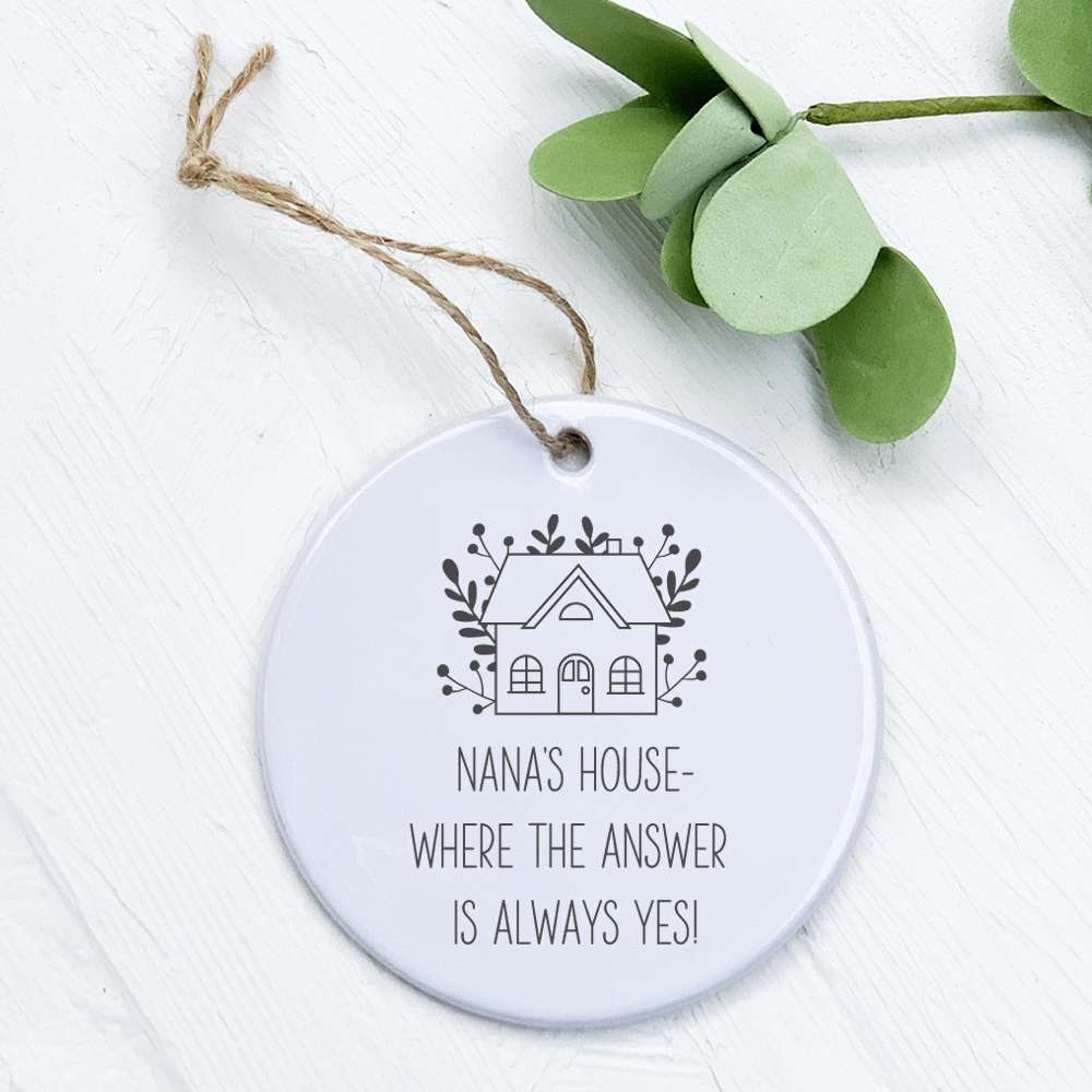 A beautifully crafted porcelain ornament featuring the phrase 'Grandma's / Nana's Answer is Yes', showcasing vibrant colors and a glossy finish.