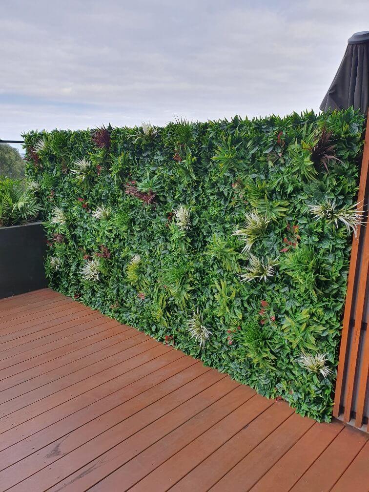 A vibrant Green Meadows Artificial Vertical Garden panel showcasing a variety of lush green plants, perfect for indoor and outdoor decoration.