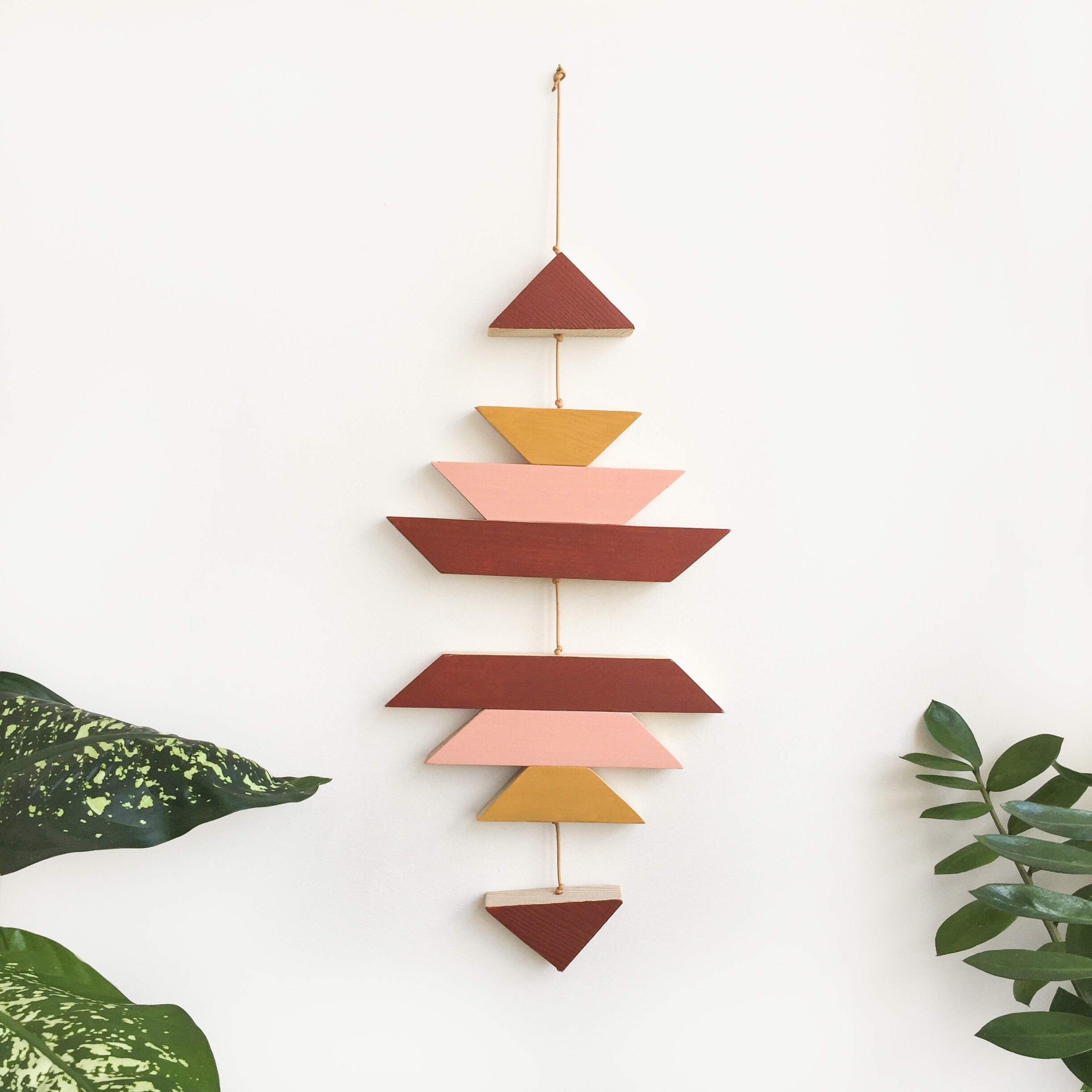 A green ombre small wooden wall hanging featuring geometric designs, connected with brown wax cotton cord, ideal for modern decor.