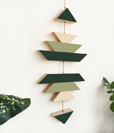 A green ombre small wooden wall hanging featuring geometric designs, connected with brown wax cotton cord, ideal for modern decor.