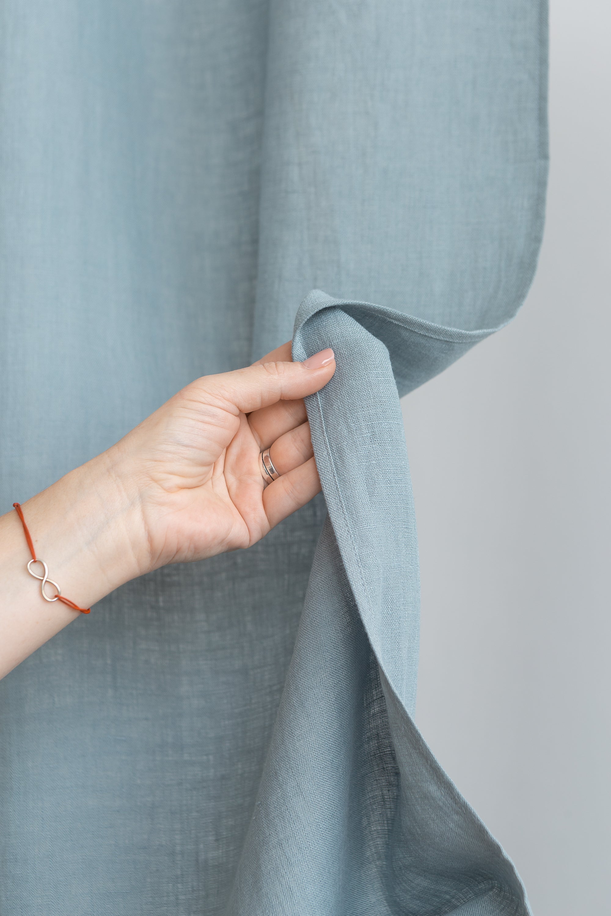 Soft greyish mint linen curtain with multifunctional tape, elegantly draped to showcase its semi-sheer texture and versatile hanging options.