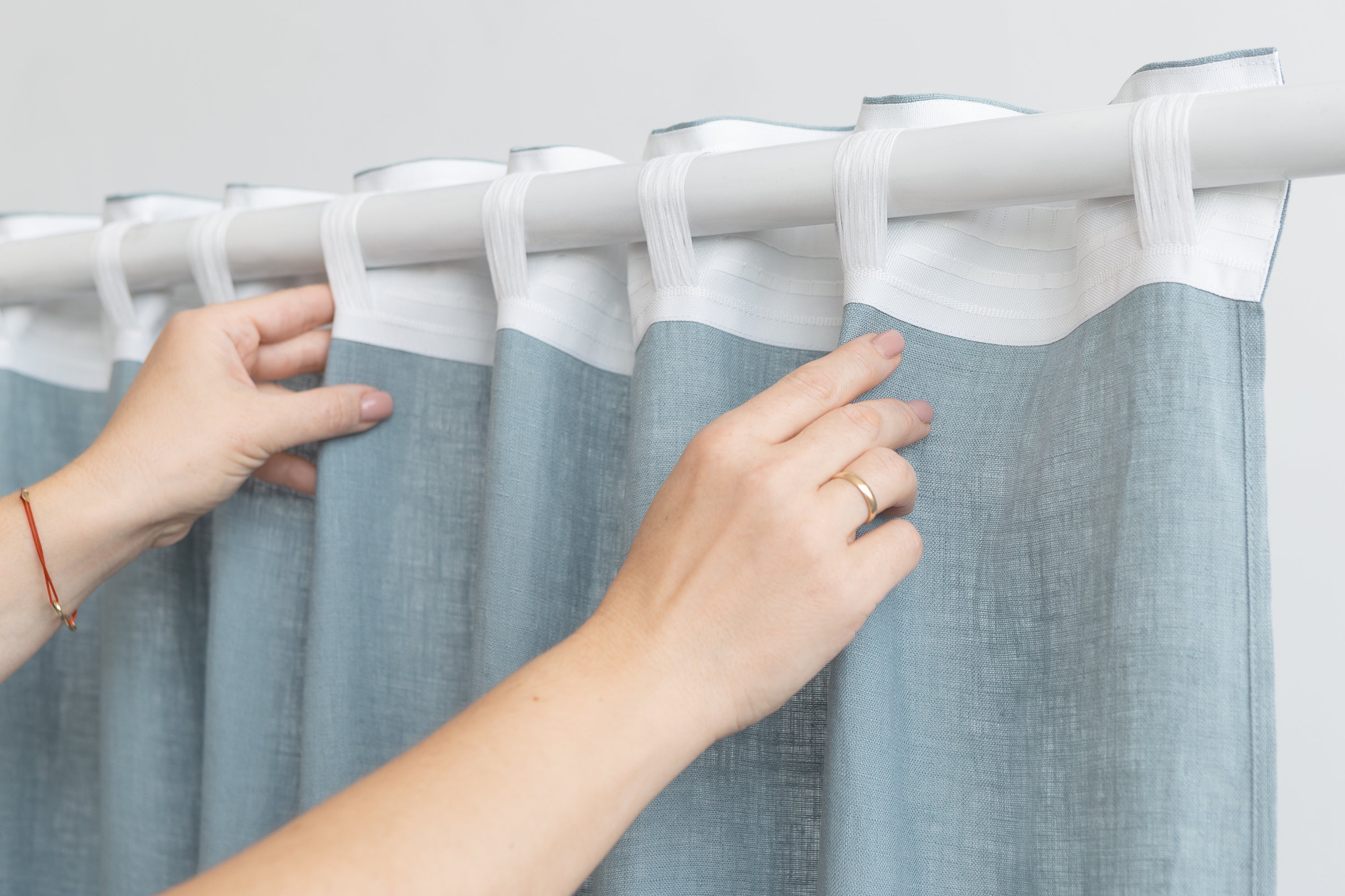 Soft greyish mint linen curtain with multifunctional tape, elegantly draped to showcase its semi-sheer texture and versatile hanging options.