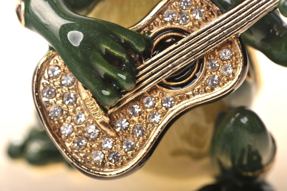 A beautifully crafted enamel painted trinket box shaped like a frog playing a guitar, adorned with Austrian crystals and 925 silver plating.