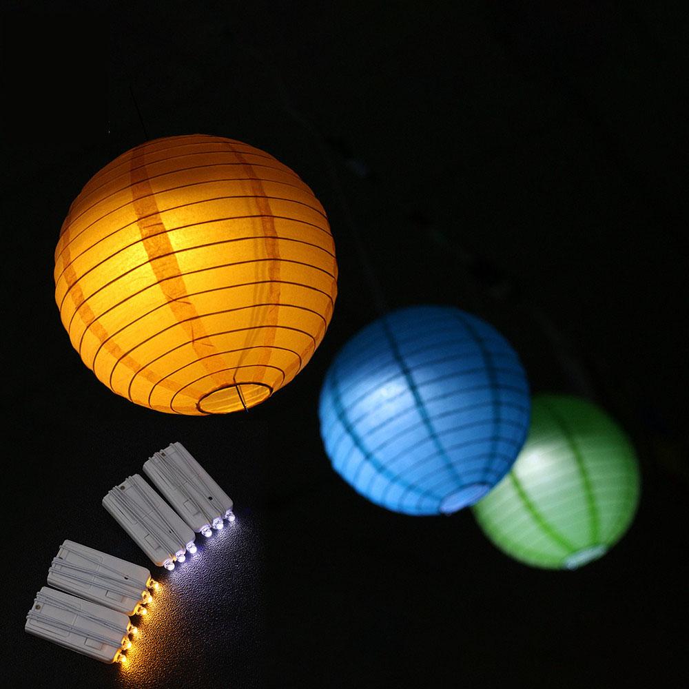 Battery operated round paper lantern ball light in warm white and multicolor, perfect for Halloween decor.