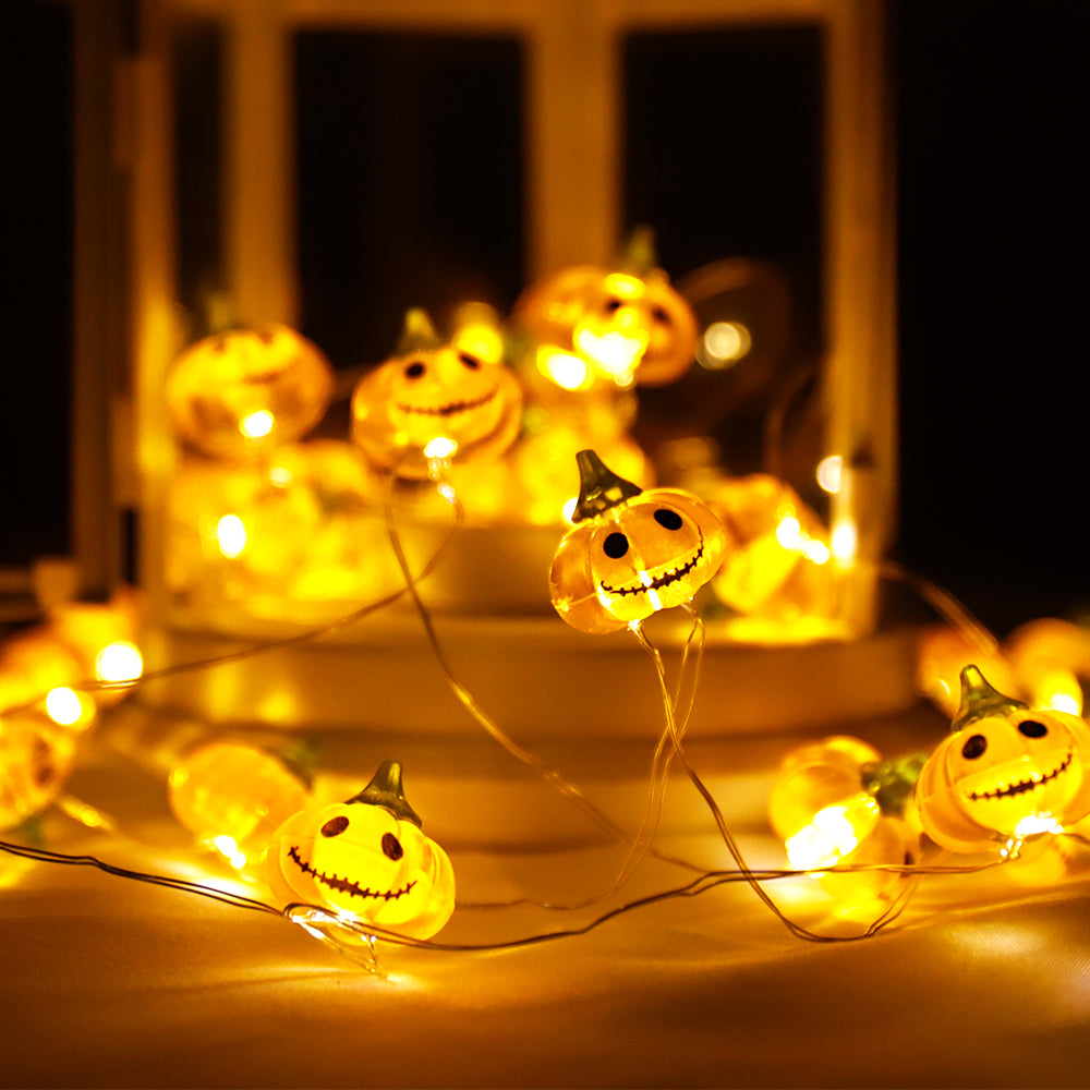 A string of Halloween Smiley Pumpkin lights glowing brightly, showcasing 30 LED pumpkins on a 9.8ft long cable, perfect for festive decorations.