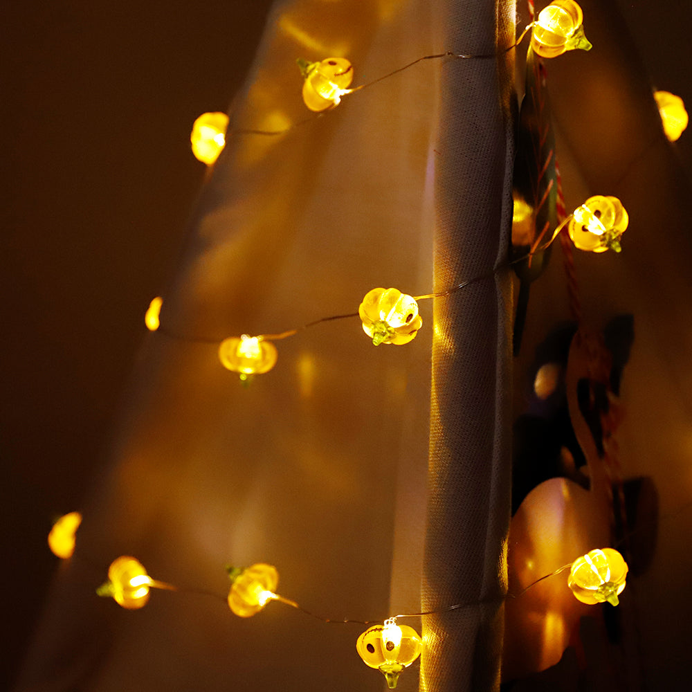 A string of Halloween Smiley Pumpkin lights glowing brightly, showcasing 30 LED pumpkins on a 9.8ft long cable, perfect for festive decorations.