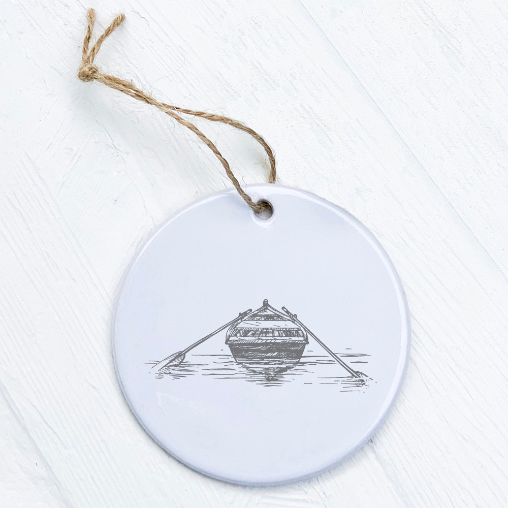 A beautifully crafted porcelain ornament featuring a hand-drawn rowboat on water, showcasing vibrant colors and a glossy finish.