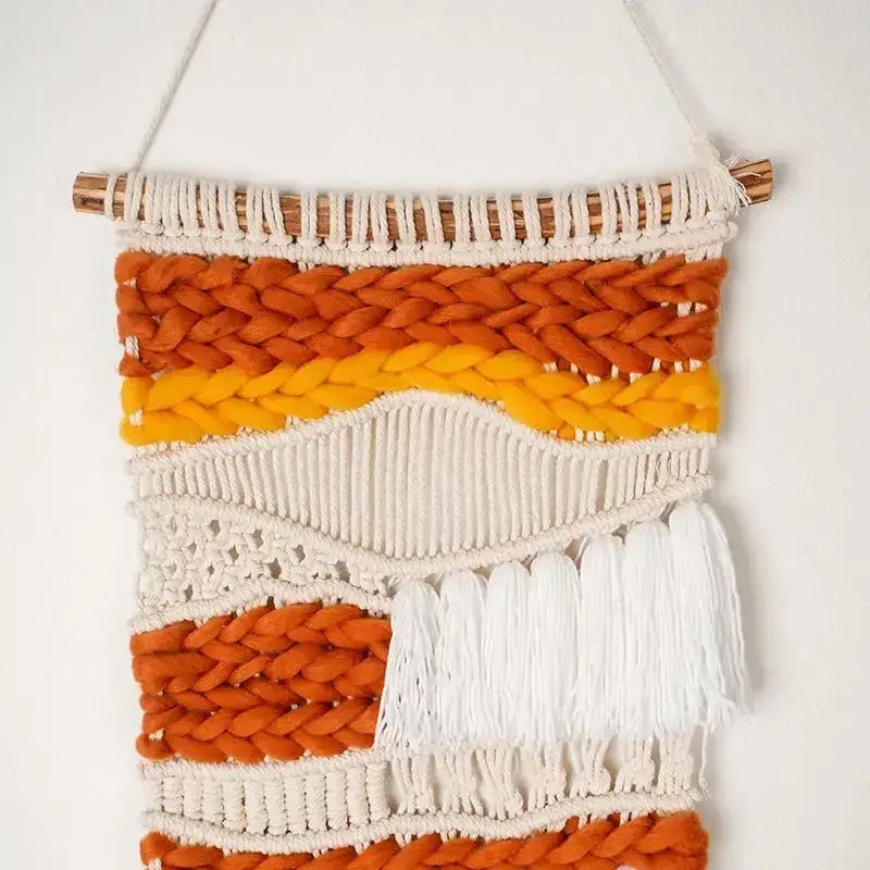 Hand Woven Cotton Wall Art in vibrant orange and white, featuring chunky elements on a wooden stick, showcasing intricate craftsmanship.