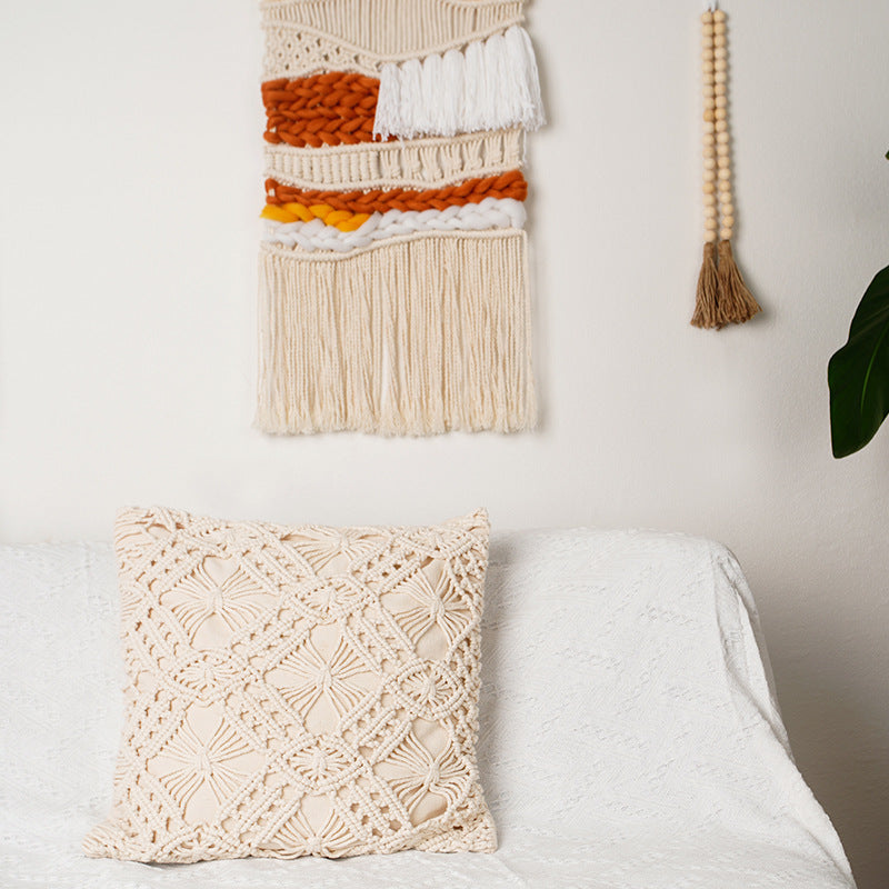 Hand Woven Cotton Wall Art in vibrant orange and white, featuring chunky elements on a wooden stick, showcasing intricate craftsmanship.