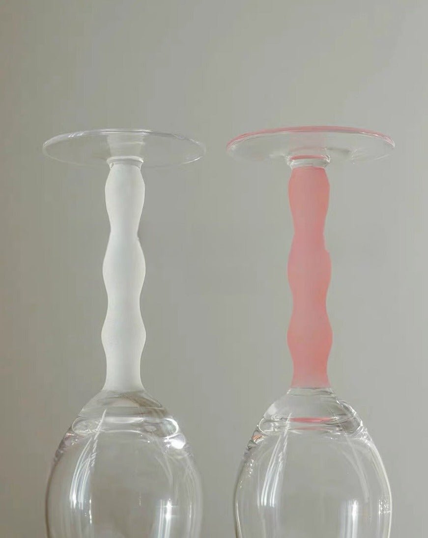 Set of 4 handblown retro rose wine glasses with colorful wavy stems, elegantly showcasing wine in transparent bowls.