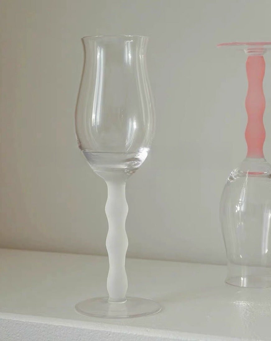 Set of 4 handblown retro rose wine glasses with colorful wavy stems, elegantly showcasing wine in transparent bowls.