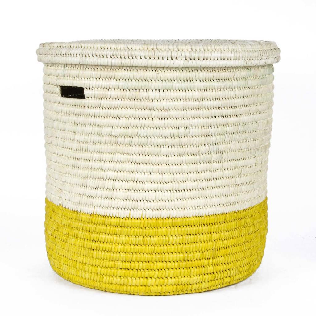 Handcrafted African laundry basket in vibrant sunflower yellow and burnt orange, showcasing intricate weaving from doum palm leaves.