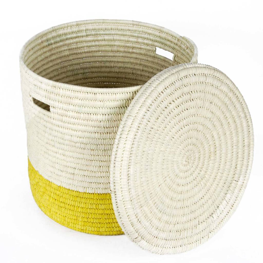 Handcrafted African laundry basket in vibrant sunflower yellow and burnt orange, showcasing intricate weaving from doum palm leaves.