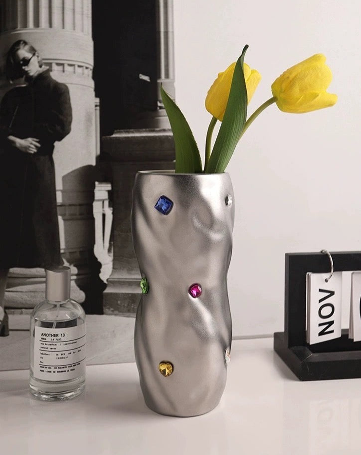 A beautifully handcrafted ceramic vase with a twisty cylinder shape, featuring trendy colors and decorative gemstone accents, perfect for modern decor.