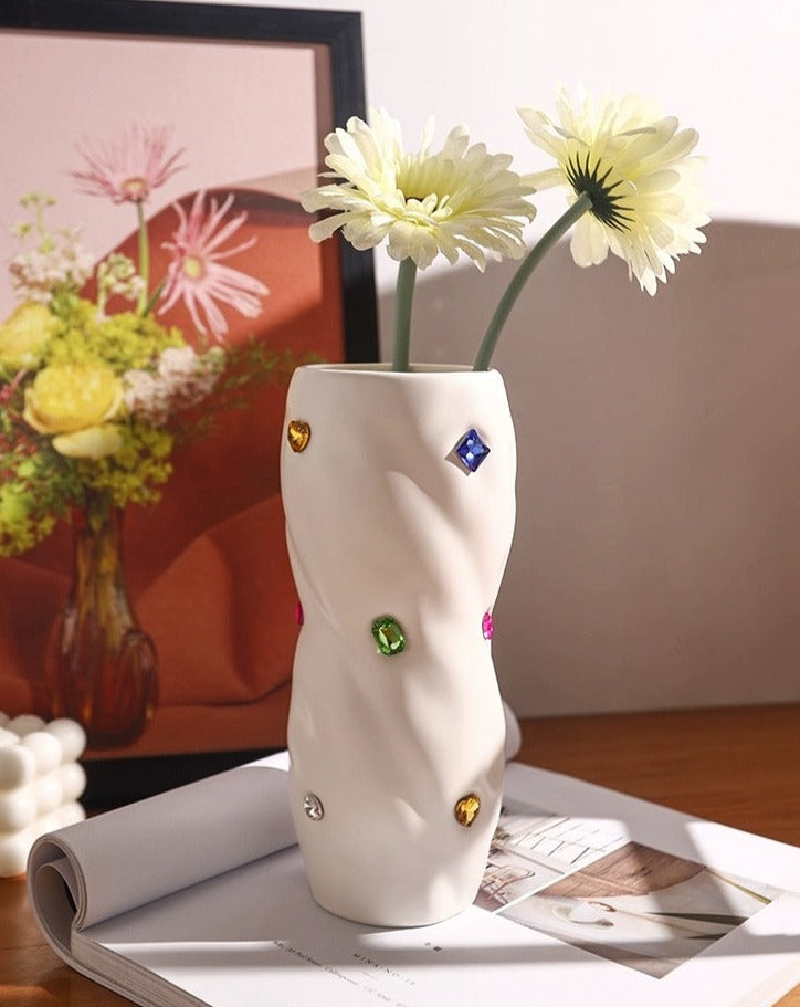 A beautifully handcrafted ceramic vase with a twisty cylinder shape, featuring trendy colors and decorative gemstone accents, perfect for modern decor.