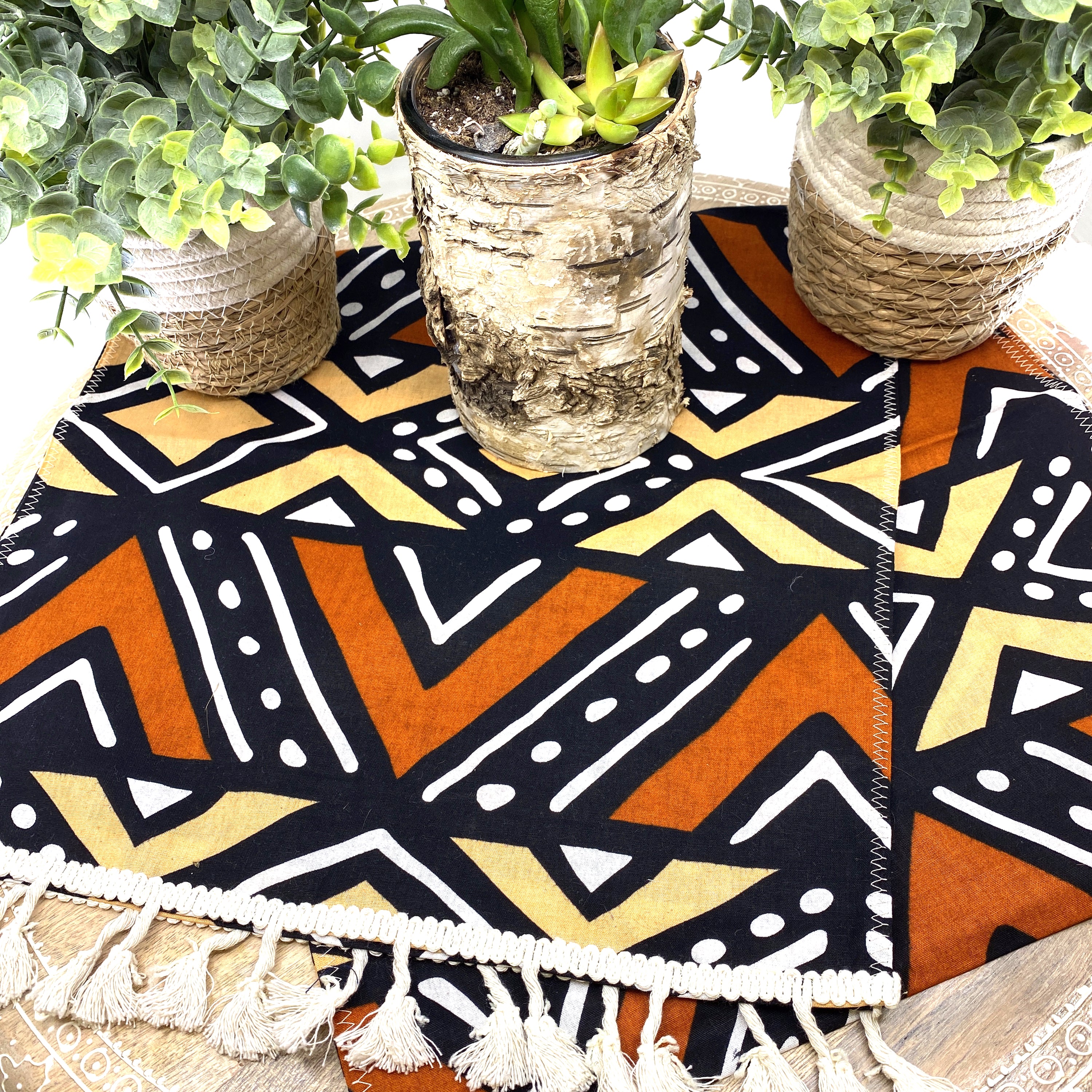 Handmade coffee table runner featuring vibrant orange Bologan wax print, showcasing intricate patterns and authentic Zimbabwean craftsmanship.