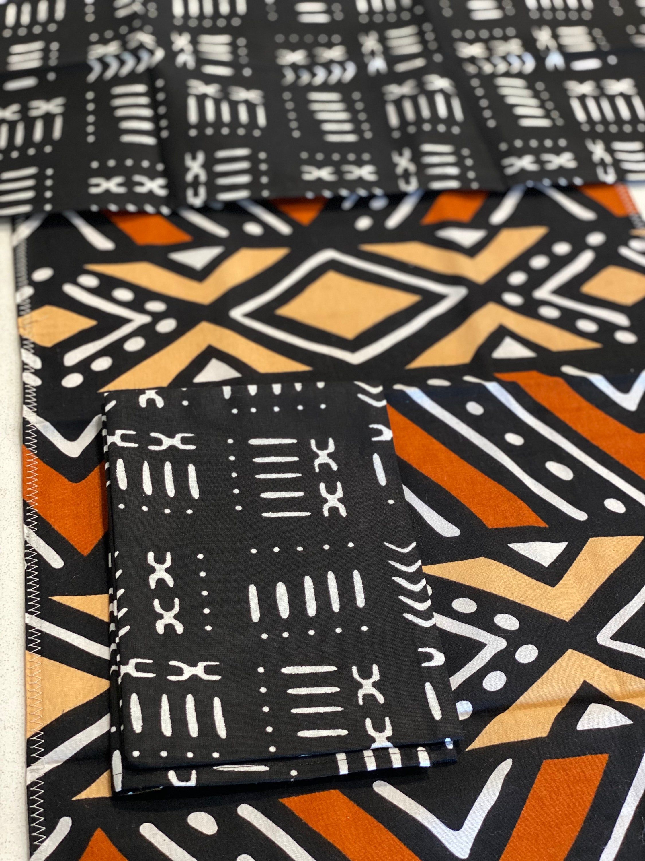 Handmade coffee table runner featuring vibrant orange Bologan wax print, showcasing intricate patterns and authentic Zimbabwean craftsmanship.