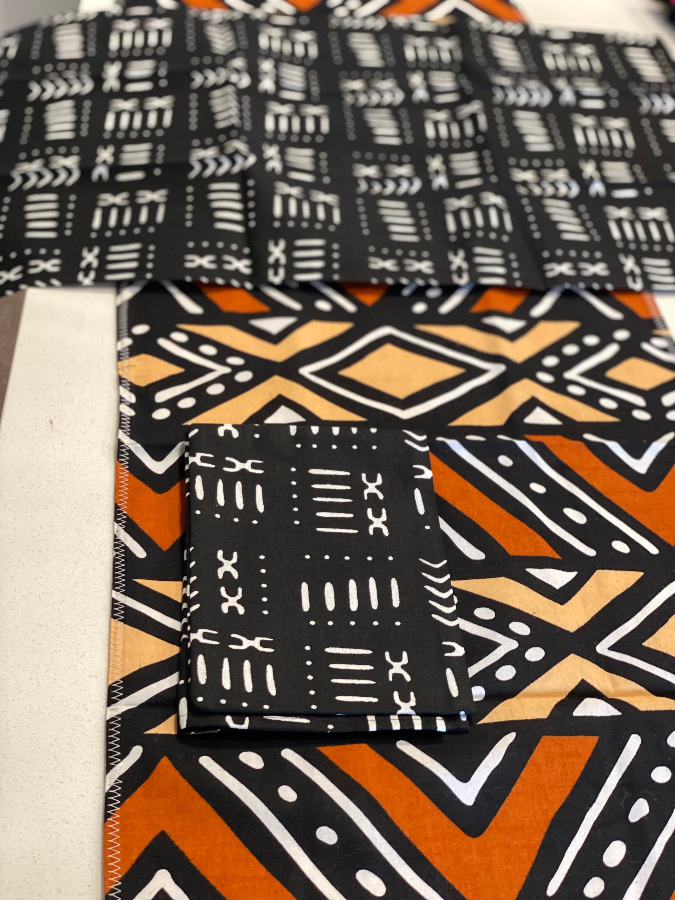 Handmade coffee table runner featuring vibrant orange Bologan wax print, showcasing intricate patterns and authentic Zimbabwean craftsmanship.