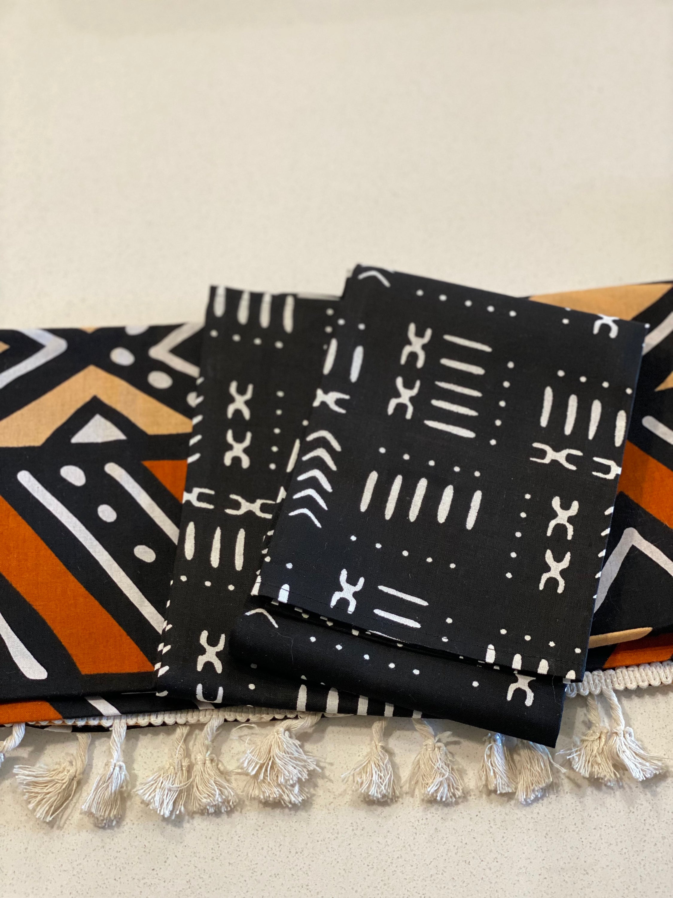 Handmade coffee table runner featuring vibrant orange Bologan wax print, showcasing intricate patterns and authentic Zimbabwean craftsmanship.