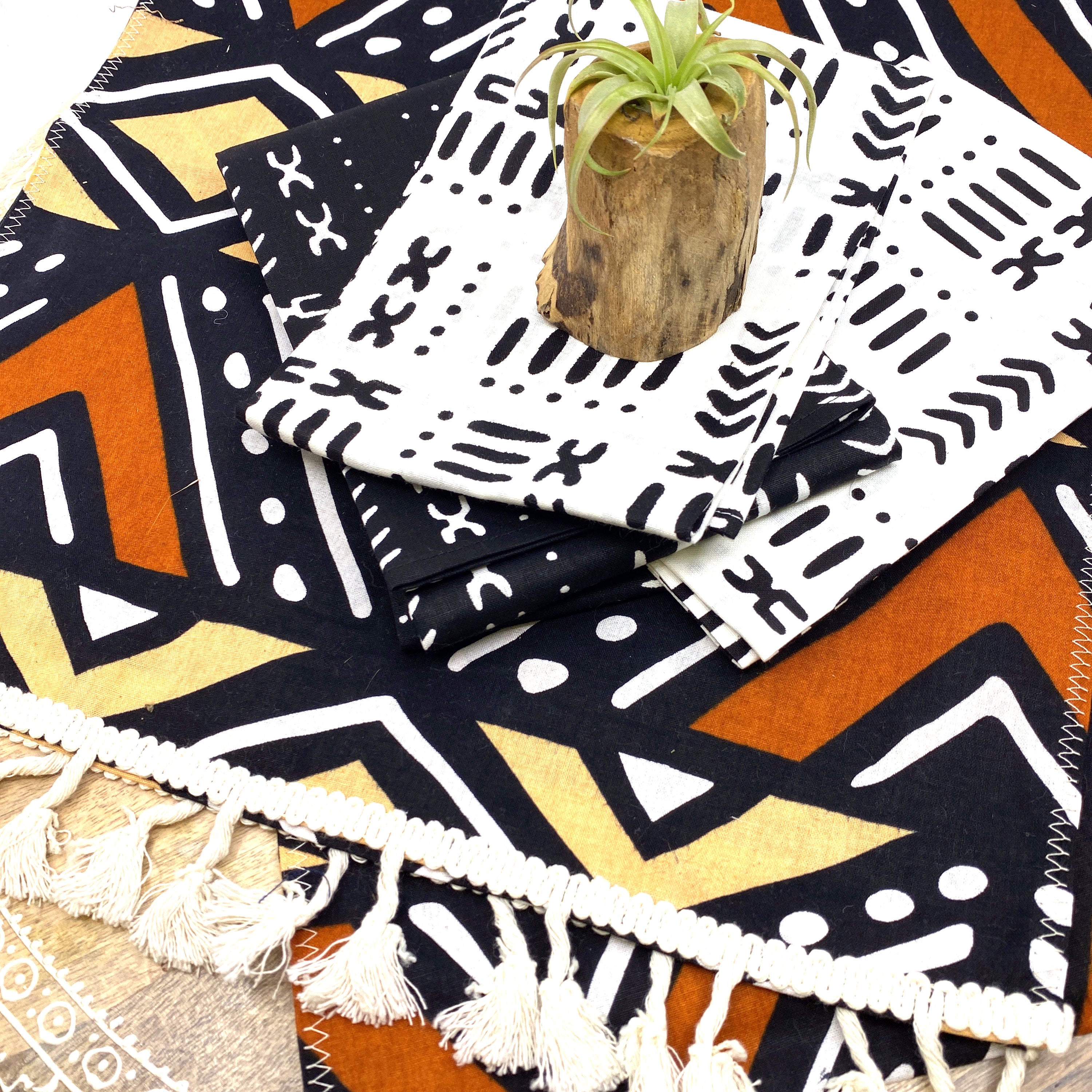 Handmade coffee table runner featuring vibrant orange Bologan wax print, showcasing intricate patterns and authentic Zimbabwean craftsmanship.