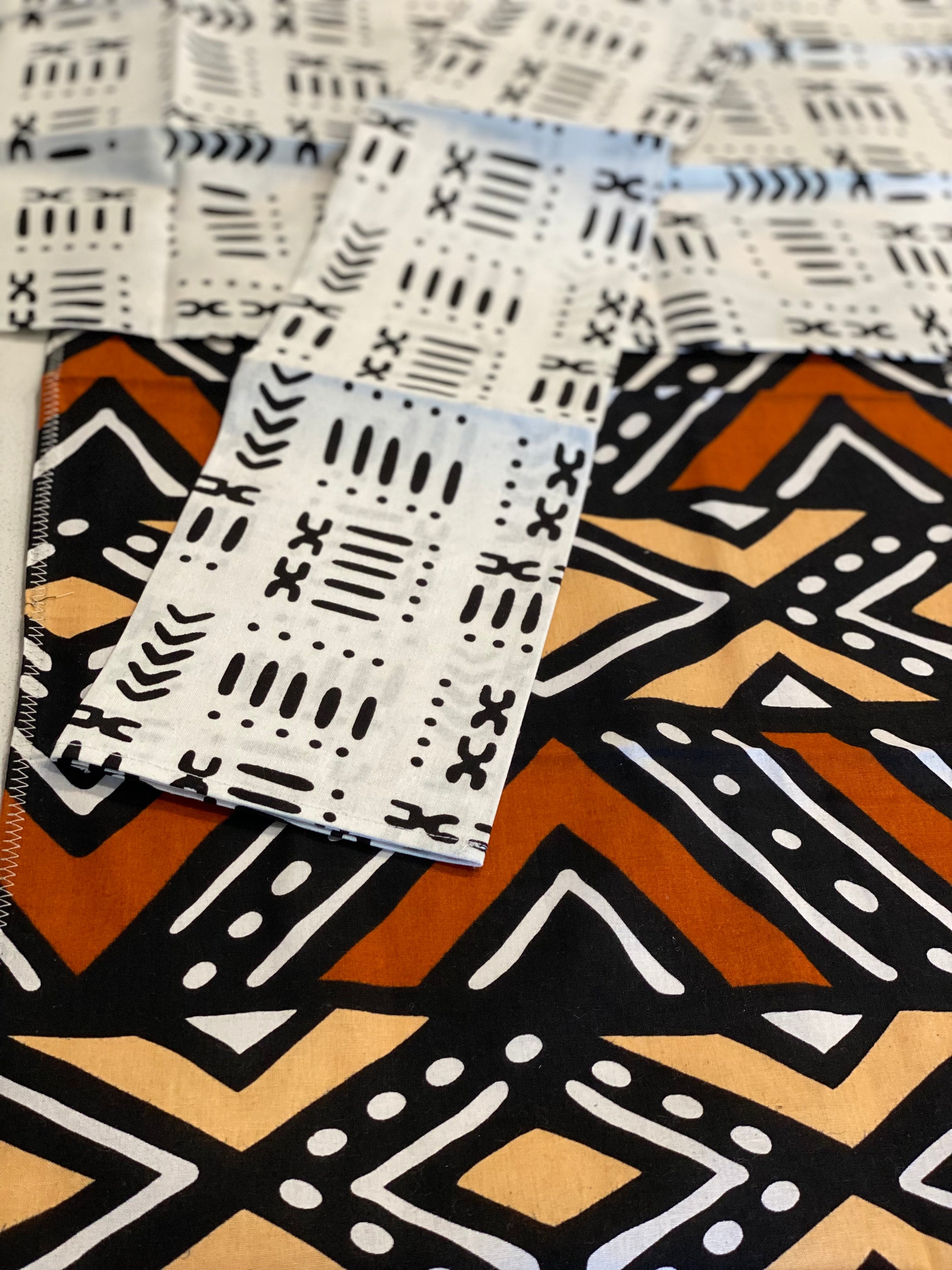 Handmade coffee table runner featuring vibrant orange Bologan wax print, showcasing intricate patterns and authentic Zimbabwean craftsmanship.