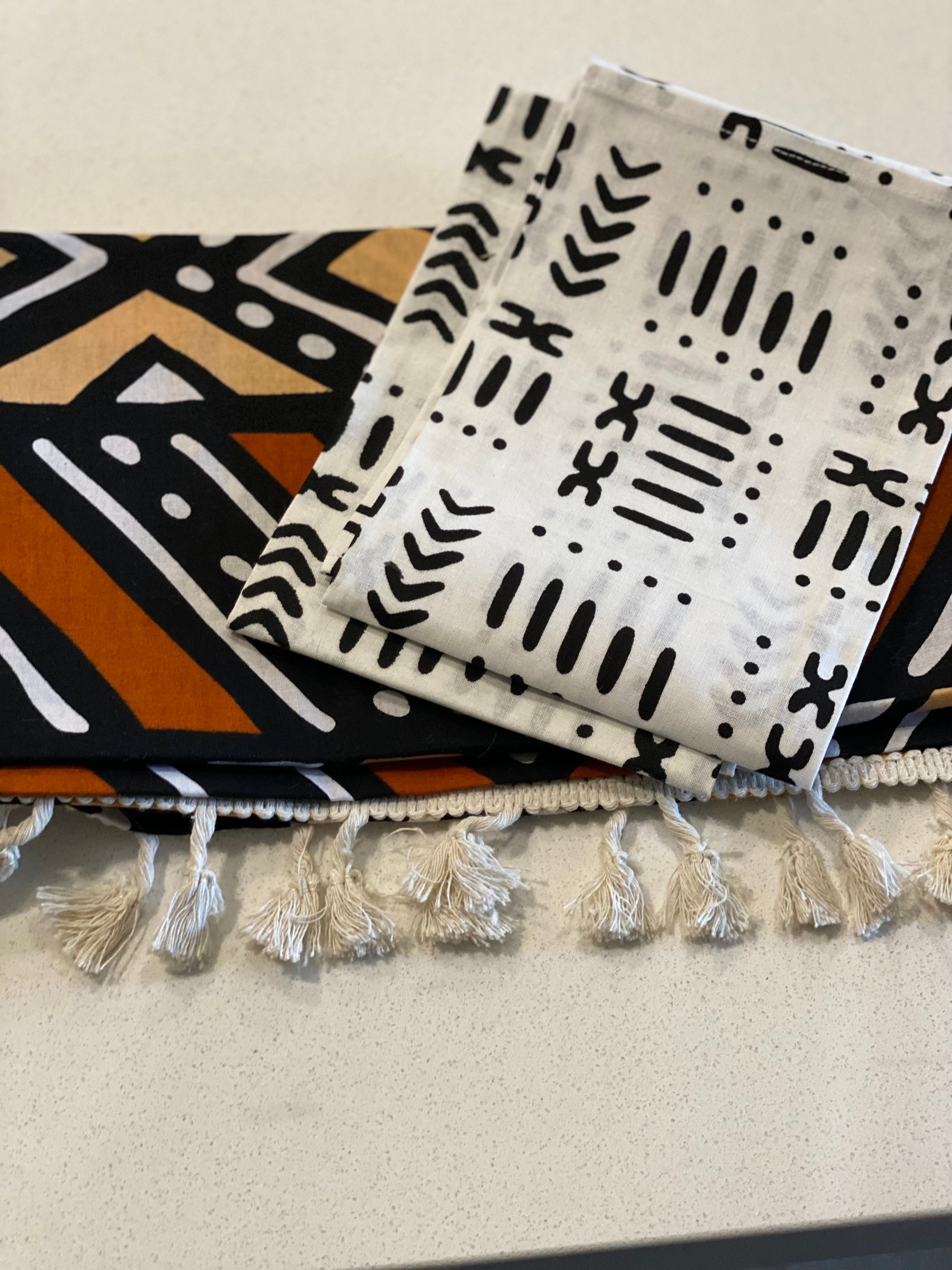 Handmade coffee table runner featuring vibrant orange Bologan wax print, showcasing intricate patterns and authentic Zimbabwean craftsmanship.