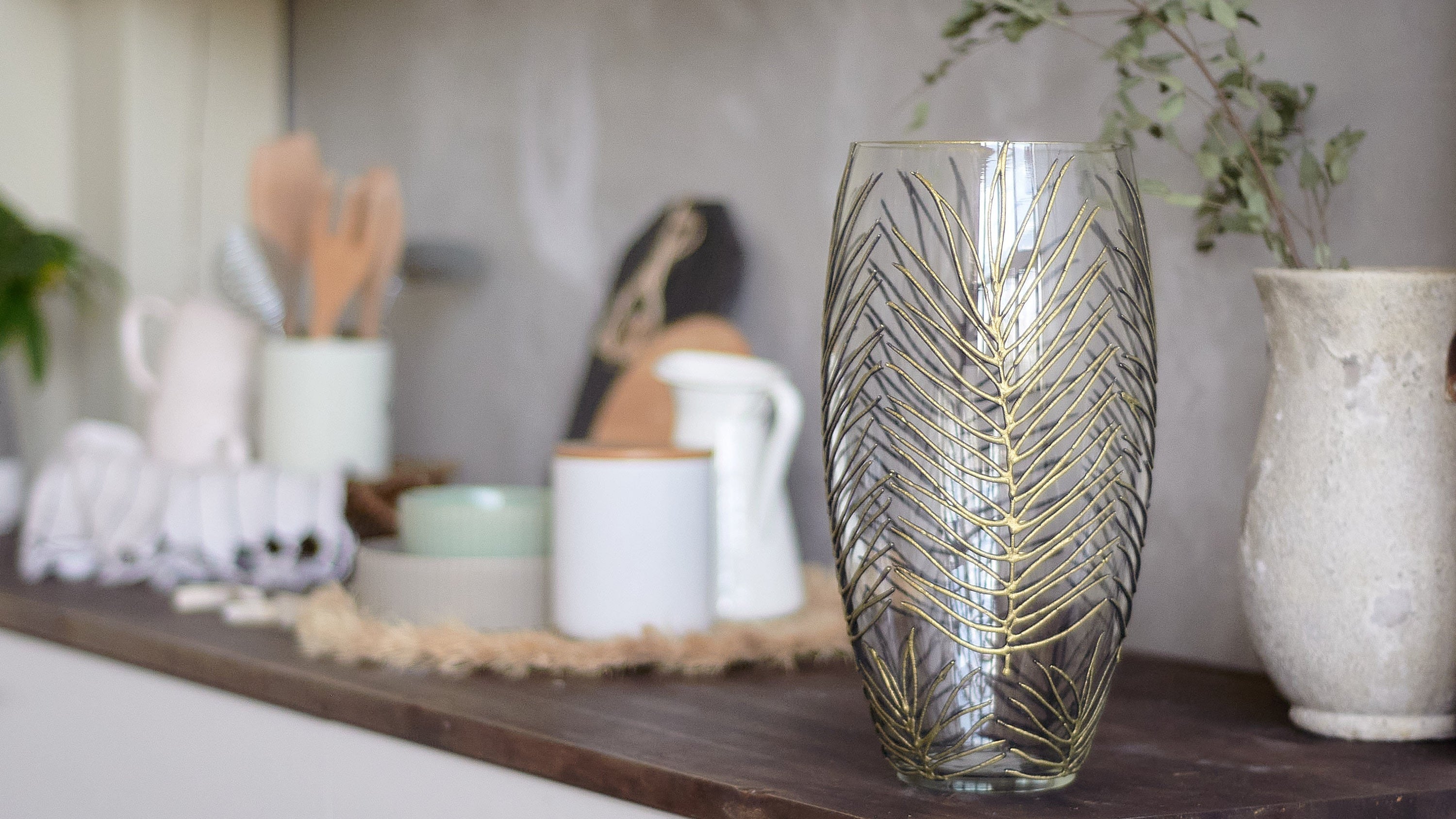 A beautifully hand-painted glass vase featuring unique floral and geometric designs, perfect for displaying flowers in any interior setting.