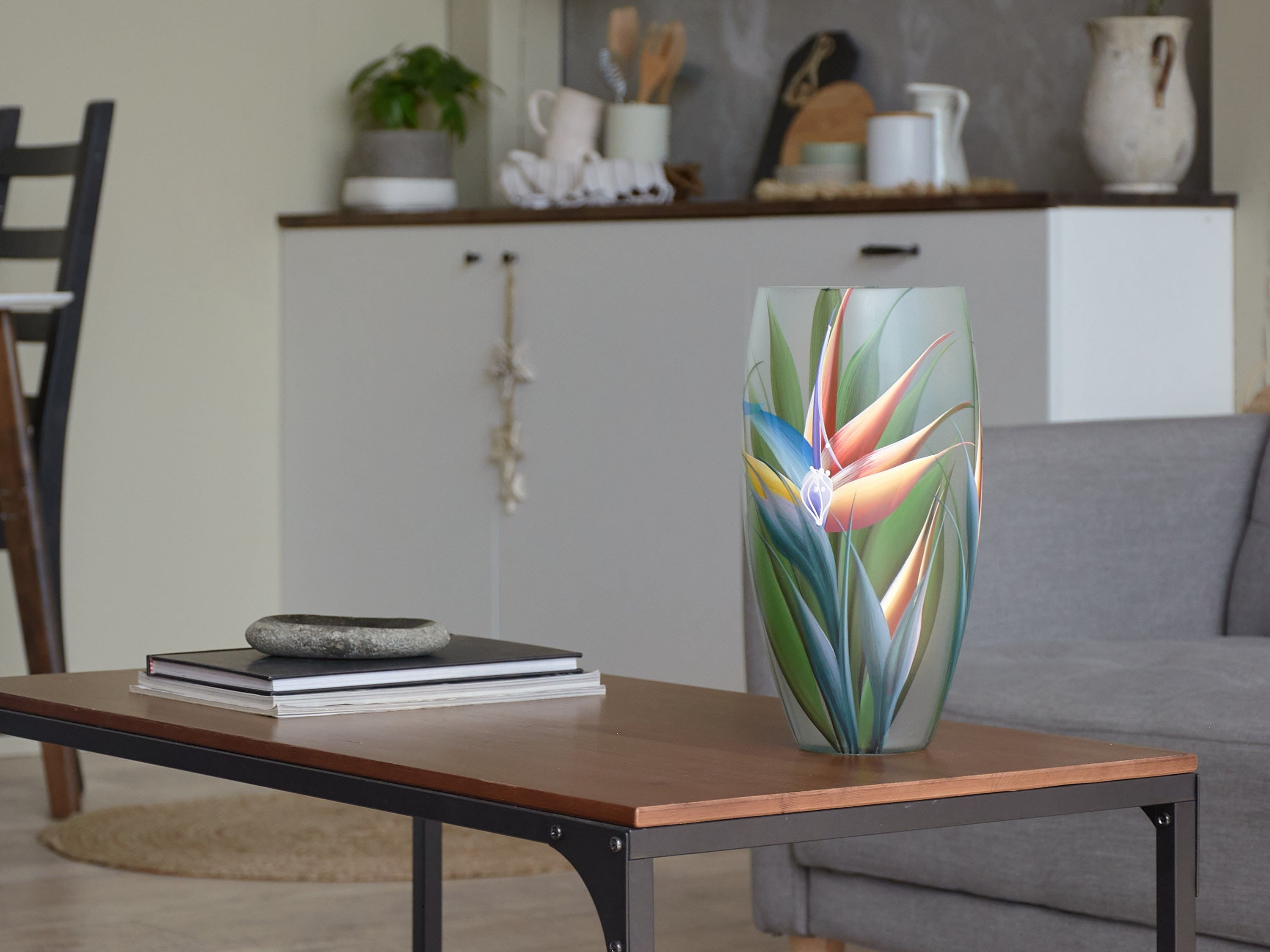 A beautifully hand-painted glass vase featuring unique floral and geometric designs, perfect for displaying flowers.