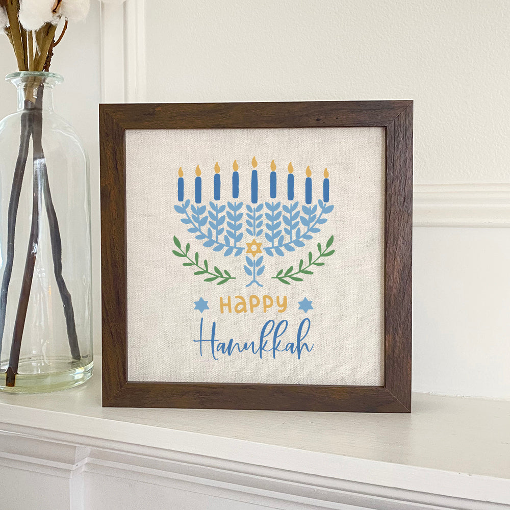 Happy Hanukkah framed sign with a wood frame, eco-friendly printing, and a linen-look background, perfect for holiday decor.