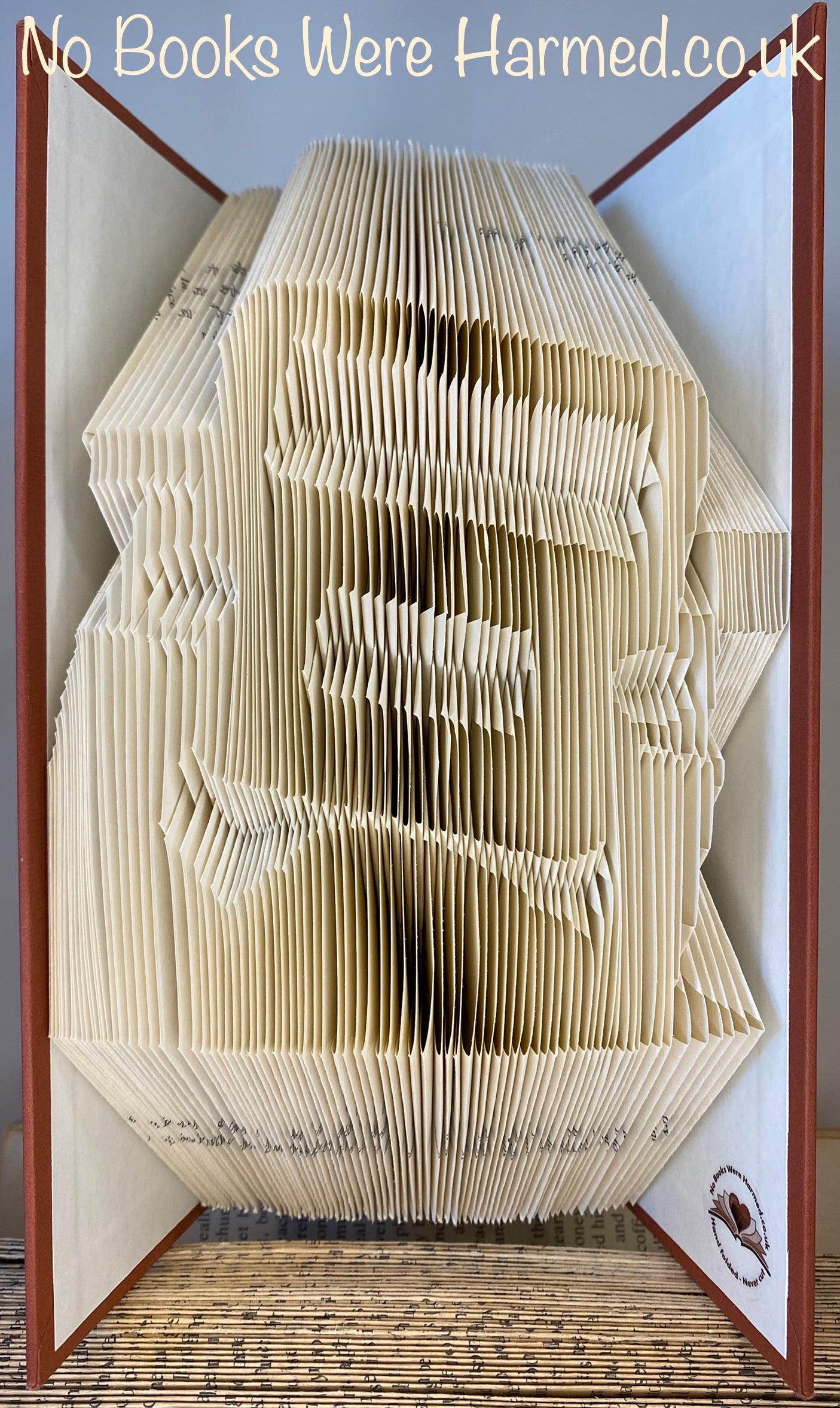 Hand-folded book art depicting a Jeep and Land Rover theme, showcasing intricate designs and vintage book pages.