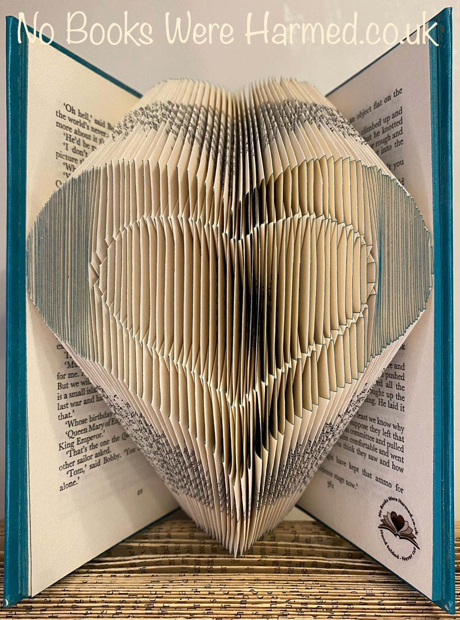 Handcrafted Heart within Heart art made from vintage book pages, showcasing intricate folds and unique design.