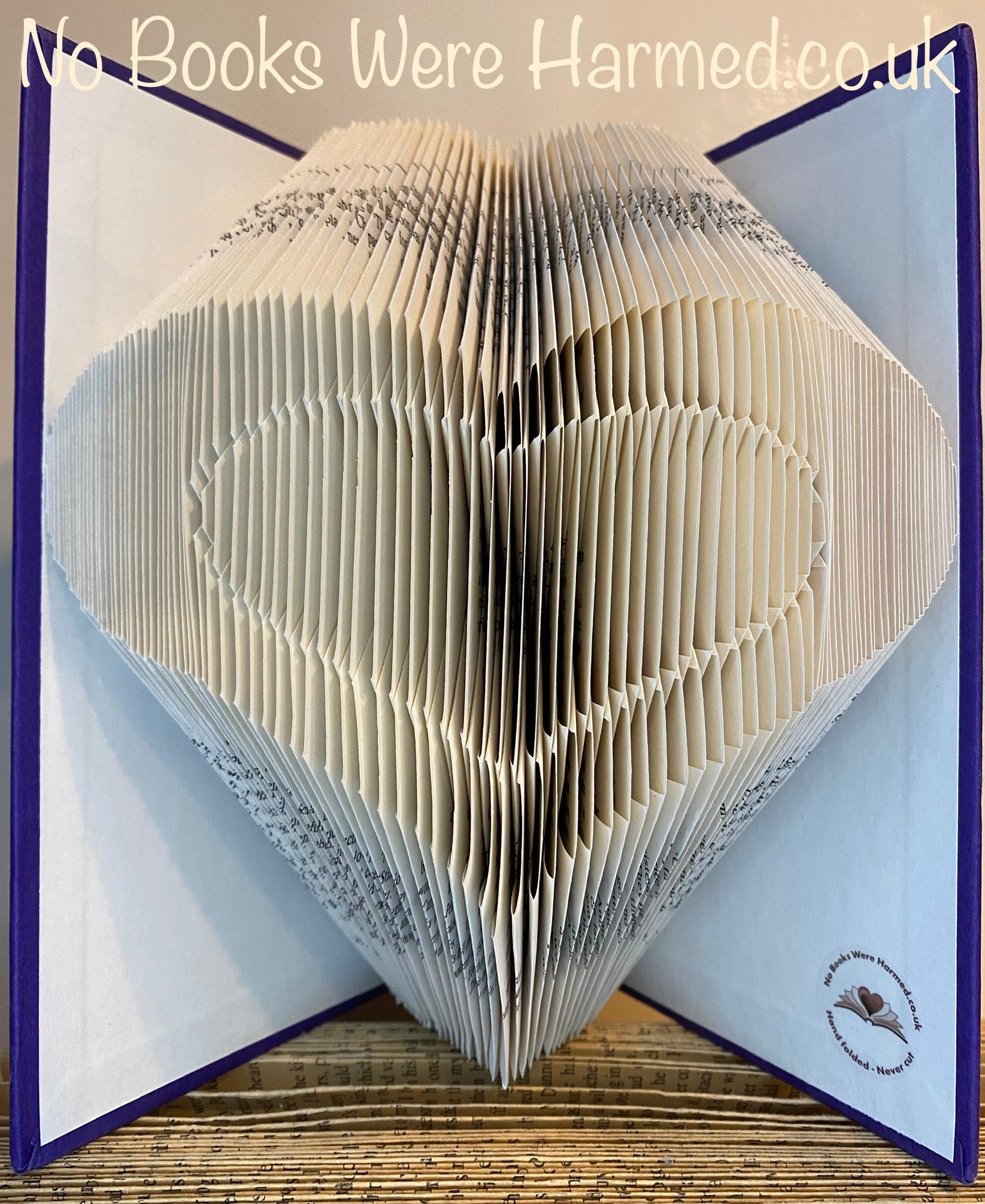 Handcrafted Heart within Heart art made from vintage book pages, showcasing intricate folds and unique design.