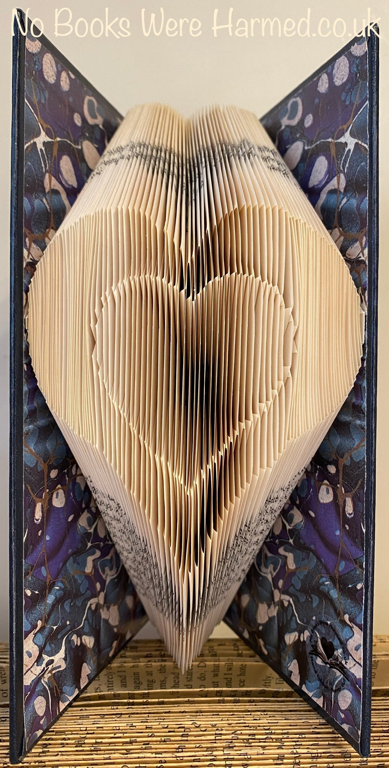 Handcrafted Heart within Heart art made from vintage book pages, showcasing intricate folds and unique design.