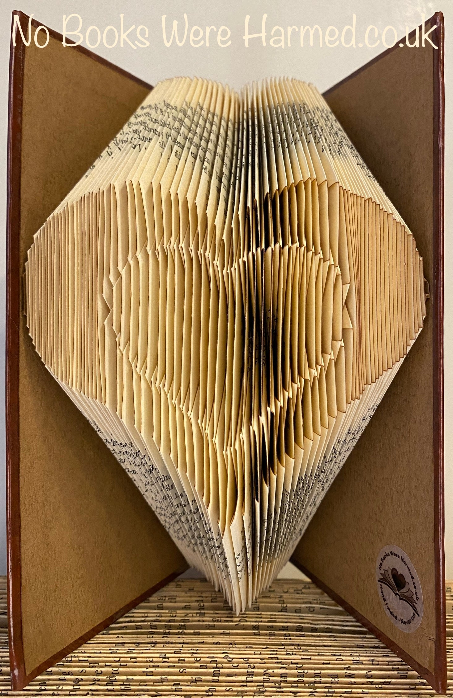 Handcrafted Heart within Heart art made from vintage book pages, showcasing intricate folds and unique design.