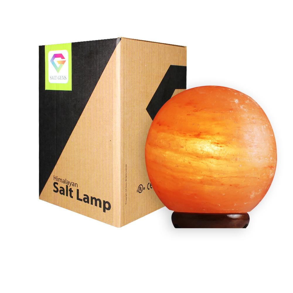 A beautifully crafted Himalayan Salt Lamp Globe made from natural salt crystals, emitting a warm amber glow, resting on a solid wooden base.