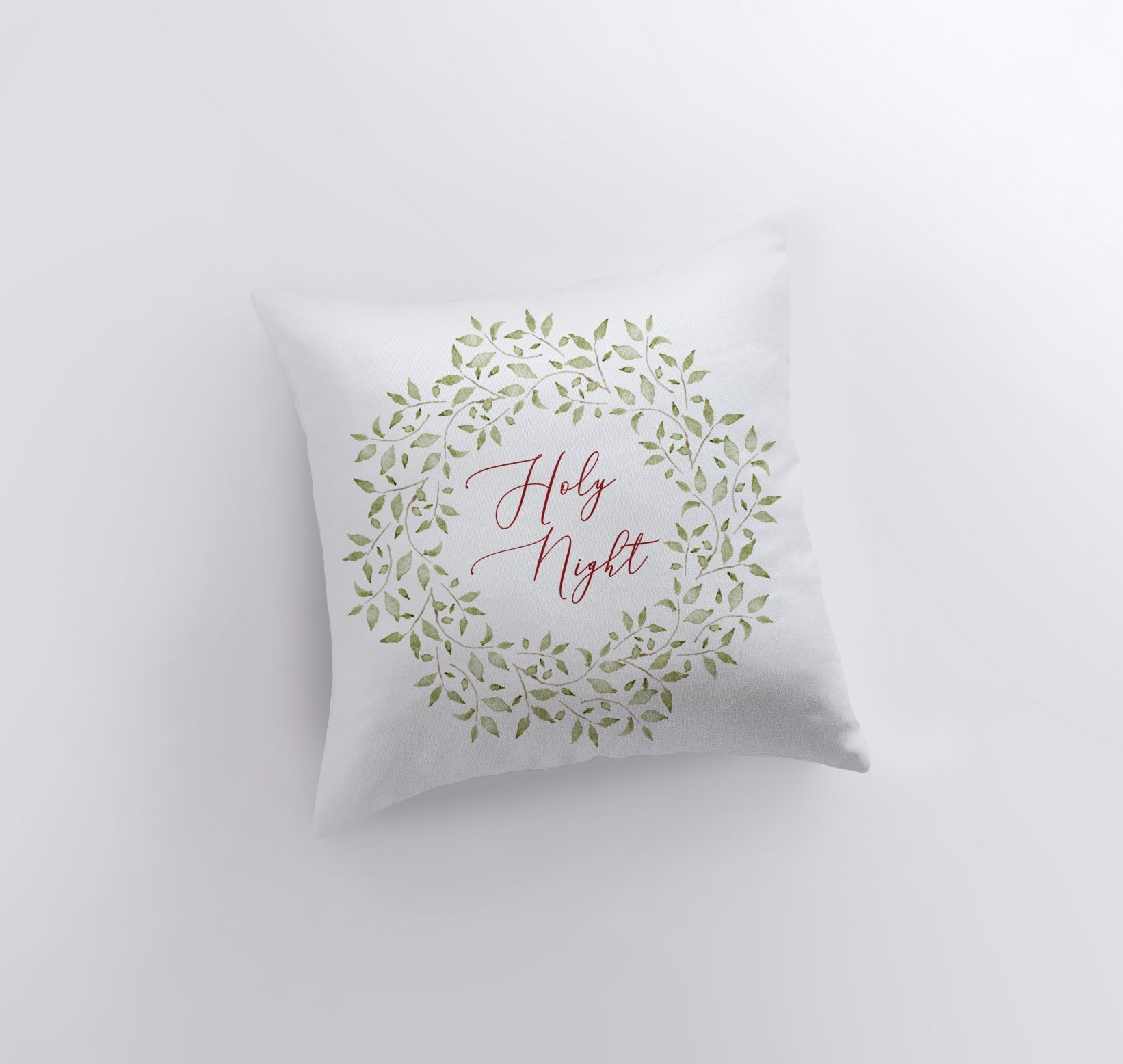 Holy Night Leaf Wreath Throw Pillow featuring red cursive text and eucalyptus wreath design on a white background.