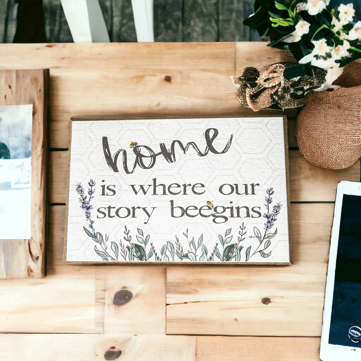 A decorative wooden block sign that reads 'HOME IS WHERE OUR STORY BEEGINS', featuring a rustic design suitable for various home decor styles.