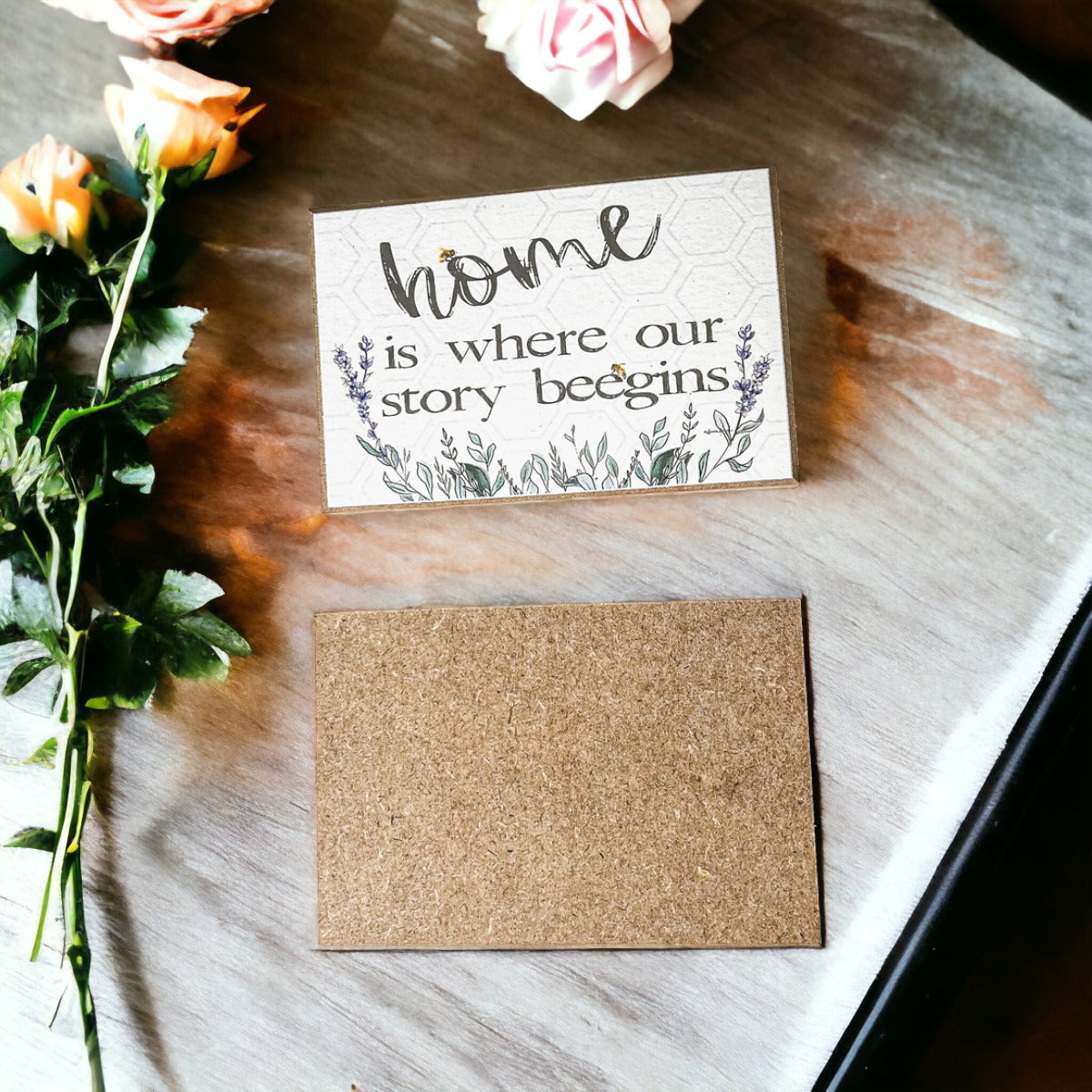 A decorative wooden block sign that reads 'HOME IS WHERE OUR STORY BEEGINS', featuring a rustic design suitable for various home decor styles.