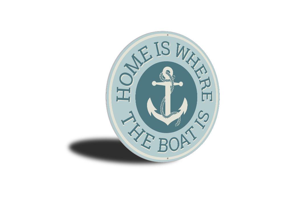 A decorative metal sign reading 'Home Is Where The Boat Is', showcasing a beautiful lakeside theme, perfect for cabin decor.