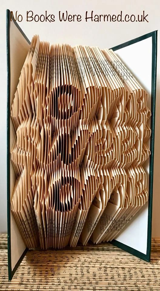 Handcrafted book art made from vintage books, showcasing unique folded pages in various colors and designs.