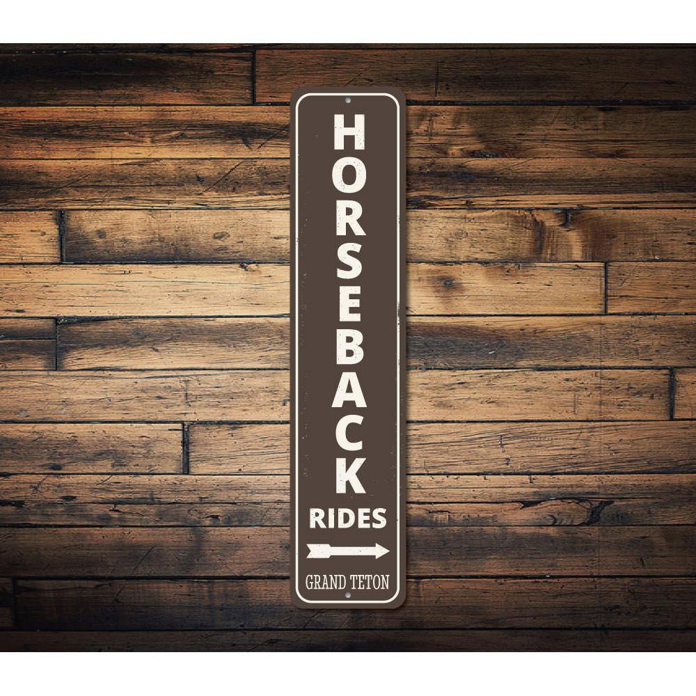 A decorative Horseback Rides Vertical Sign made of high-quality aluminum, showcasing a rustic design perfect for lakeside decor.