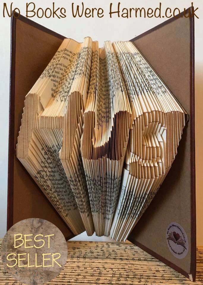 Handcrafted 'Hug' art piece made from vintage book pages, showcasing intricate folds and unique design.