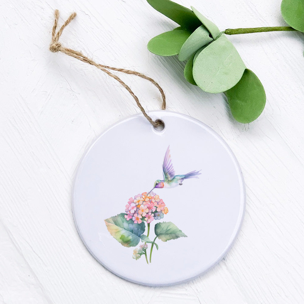 A beautifully crafted porcelain ornament featuring a hummingbird and lantana flowers, showcasing vibrant colors and a glossy finish.