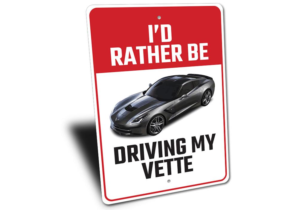 Metal sign featuring the phrase 'I'd Rather Be Driving My Corvette', showcasing a sleek design perfect for car enthusiasts.